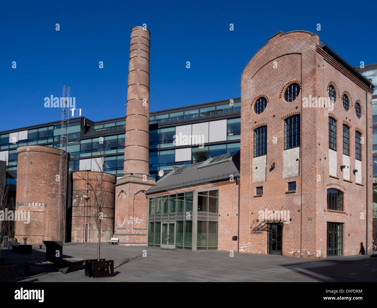 Palazzi in mattoni rossi e il camino dal vecchio papermill integrato nella moderna architettura urbana Drammen Norvegia Foto Stock