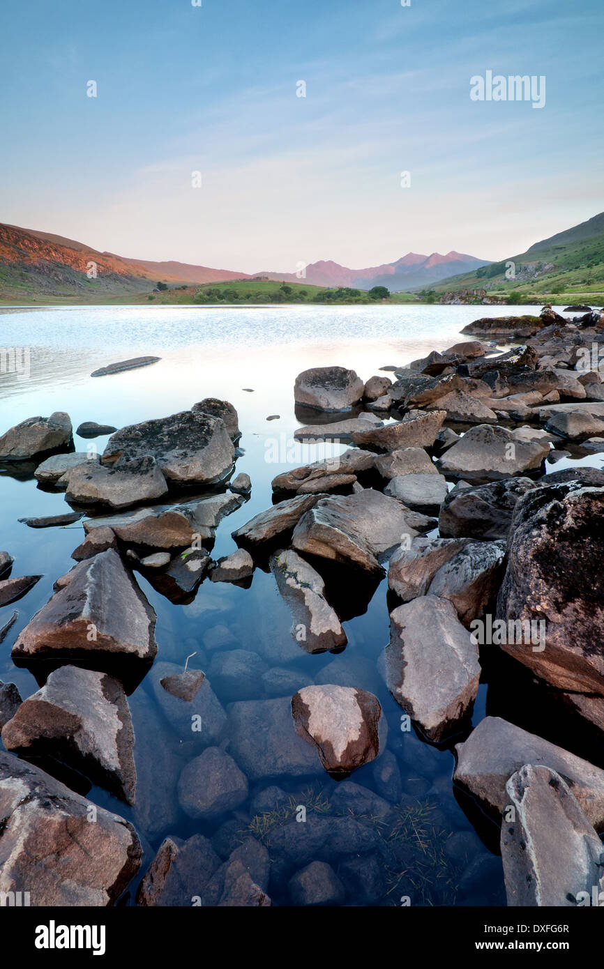 Il sole catture la Snowdon horseshoe nella distanza oltre Llyn Mymbyr. Foto Stock