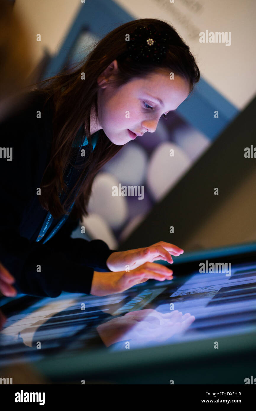 Educazione musicale: una scuola primaria bambine fare musica con grande schermo sensibile al tocco di computer in classe lezione in aula, il Galles, Regno Unito Foto Stock