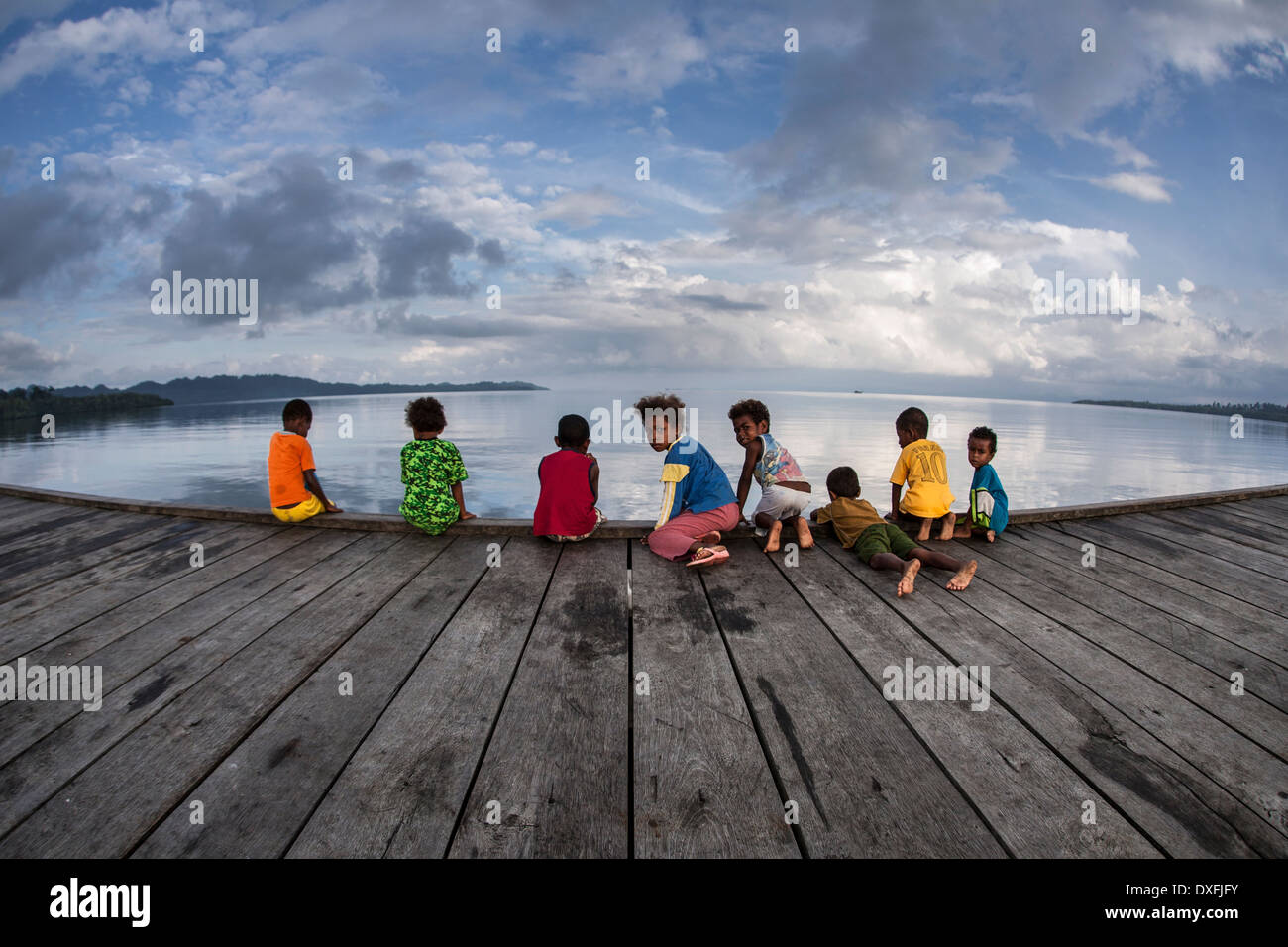 I bambini di Papua play sul dock di villaggio, Raja Ampat, Papua occidentale, in Indonesia Foto Stock