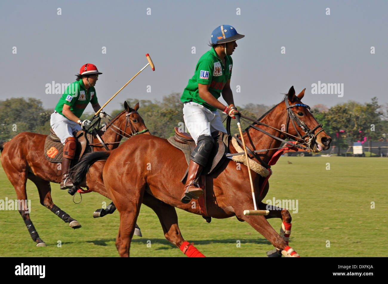 Due giocatori di polo canter attraverso il campo a Cartier corrispondono a Nuova Delhi Foto Stock