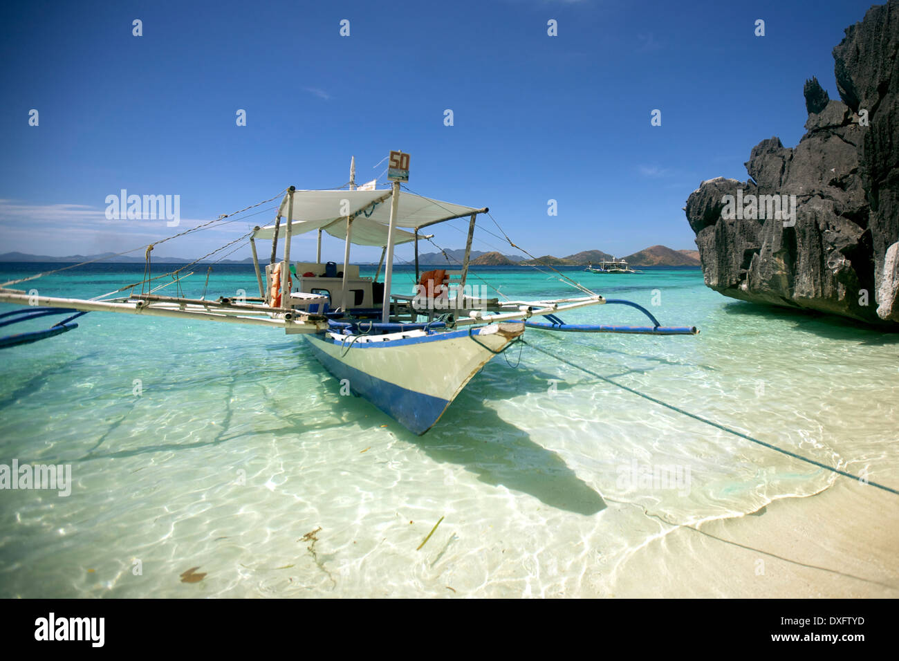 Il noleggio di una barca ancorata ad una spiaggia dorata in Coron Island, Philippinnes Foto Stock