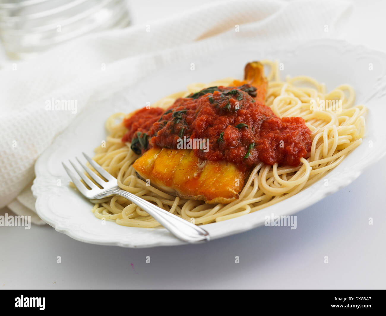 Spaghetti con pesce in pomodoro e salsa di spinaci Foto Stock