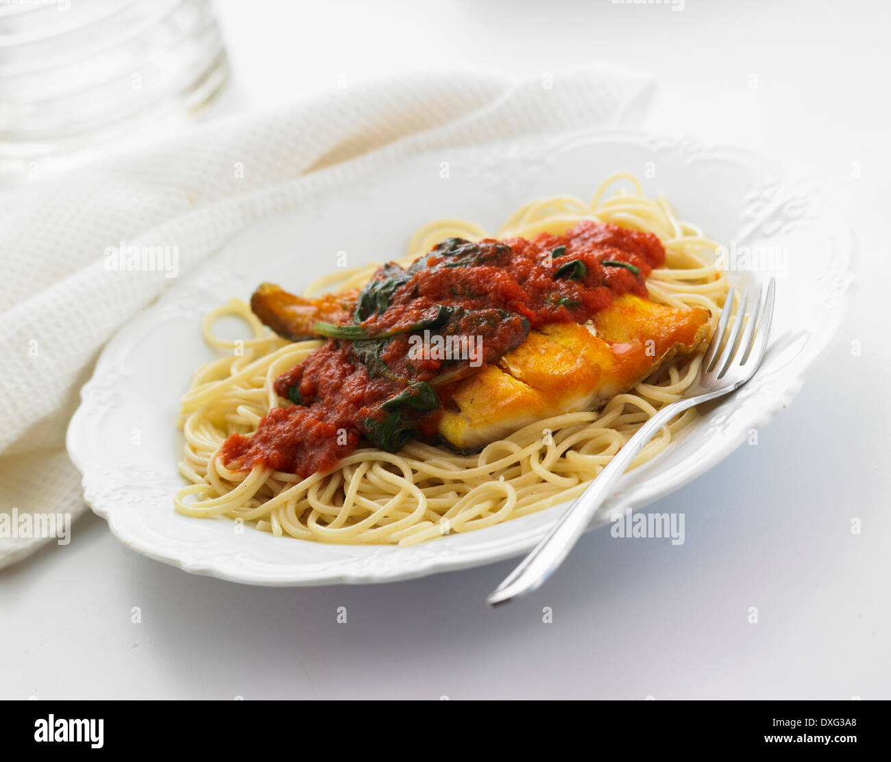Spaghetti con pesce in pomodoro e salsa di spinaci Foto Stock