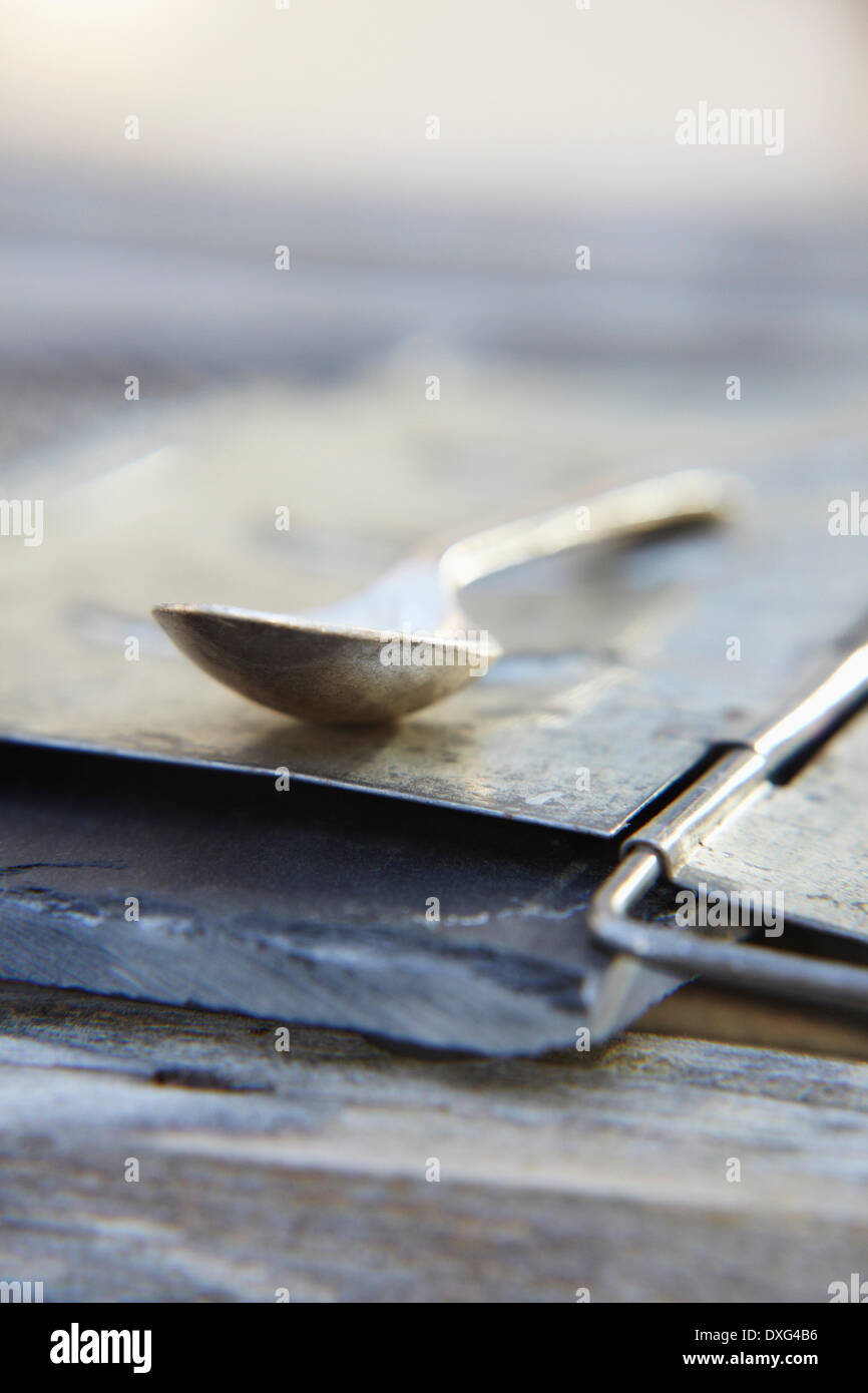 Vista astratta del cucchiaio di metallo sull'Ardesia Foto Stock