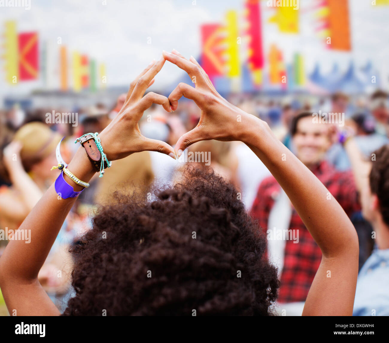 Donna cuore di formatura-forma con le mani al festival di musica Foto Stock