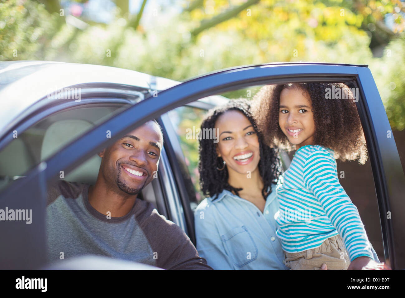 Ritratto di famiglia felice all'interno e al di fuori della vettura Foto Stock