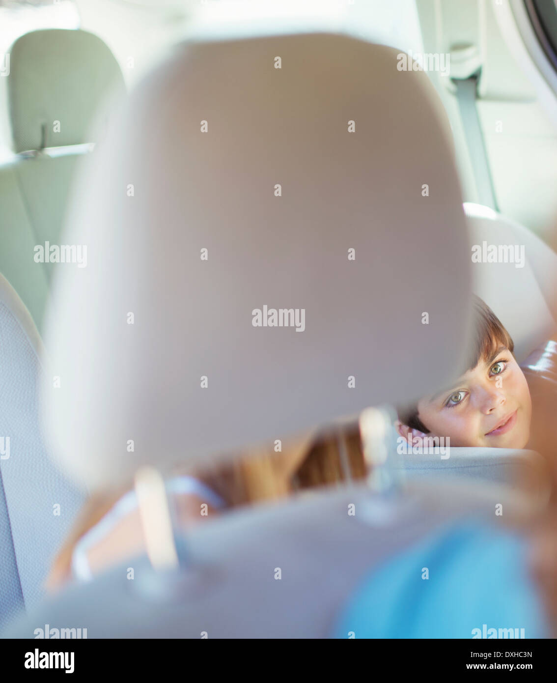 Madre girando per parlare ai bambini nel sedile posteriore della macchina Foto Stock