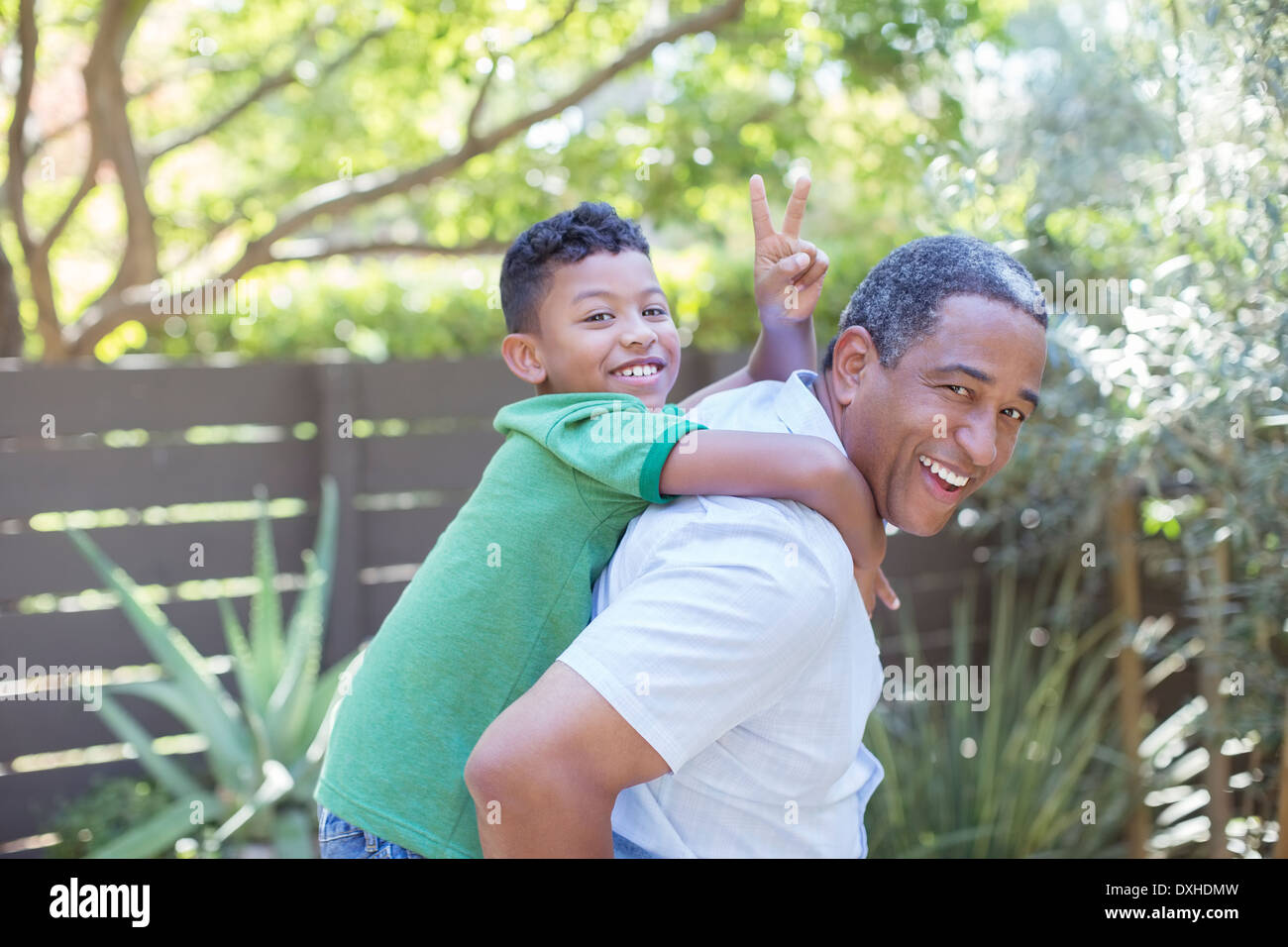 Ritratto di felice nonno piggybacking nipote Foto Stock