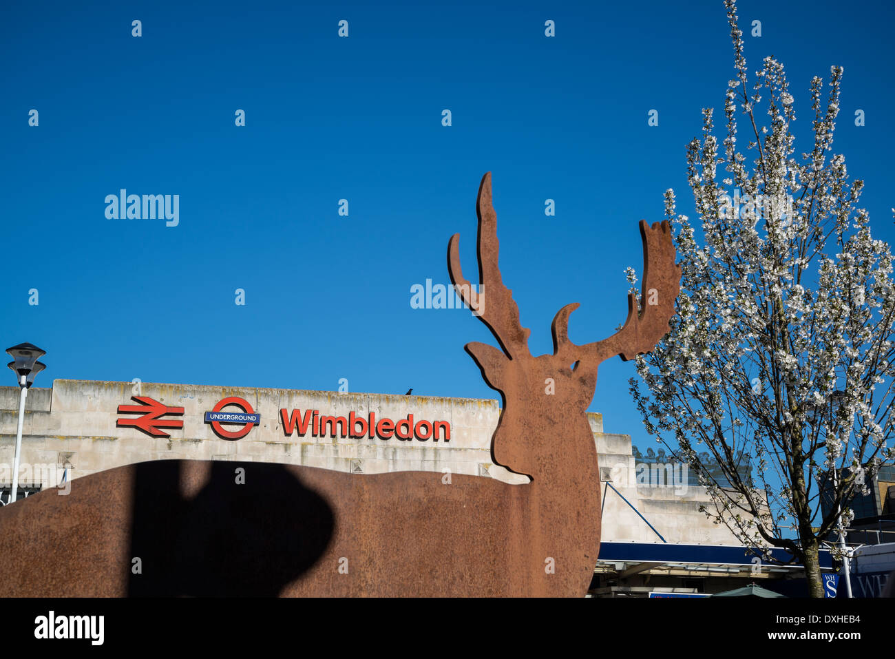 Wimbledon stazione ferroviaria con i cervi scultura e albero in fiore, London, Regno Unito Foto Stock