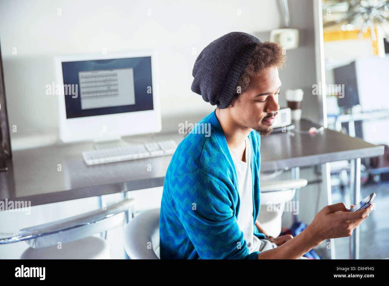 Casual uomo d affari per la messaggistica di testo con il cellulare in ufficio Foto Stock