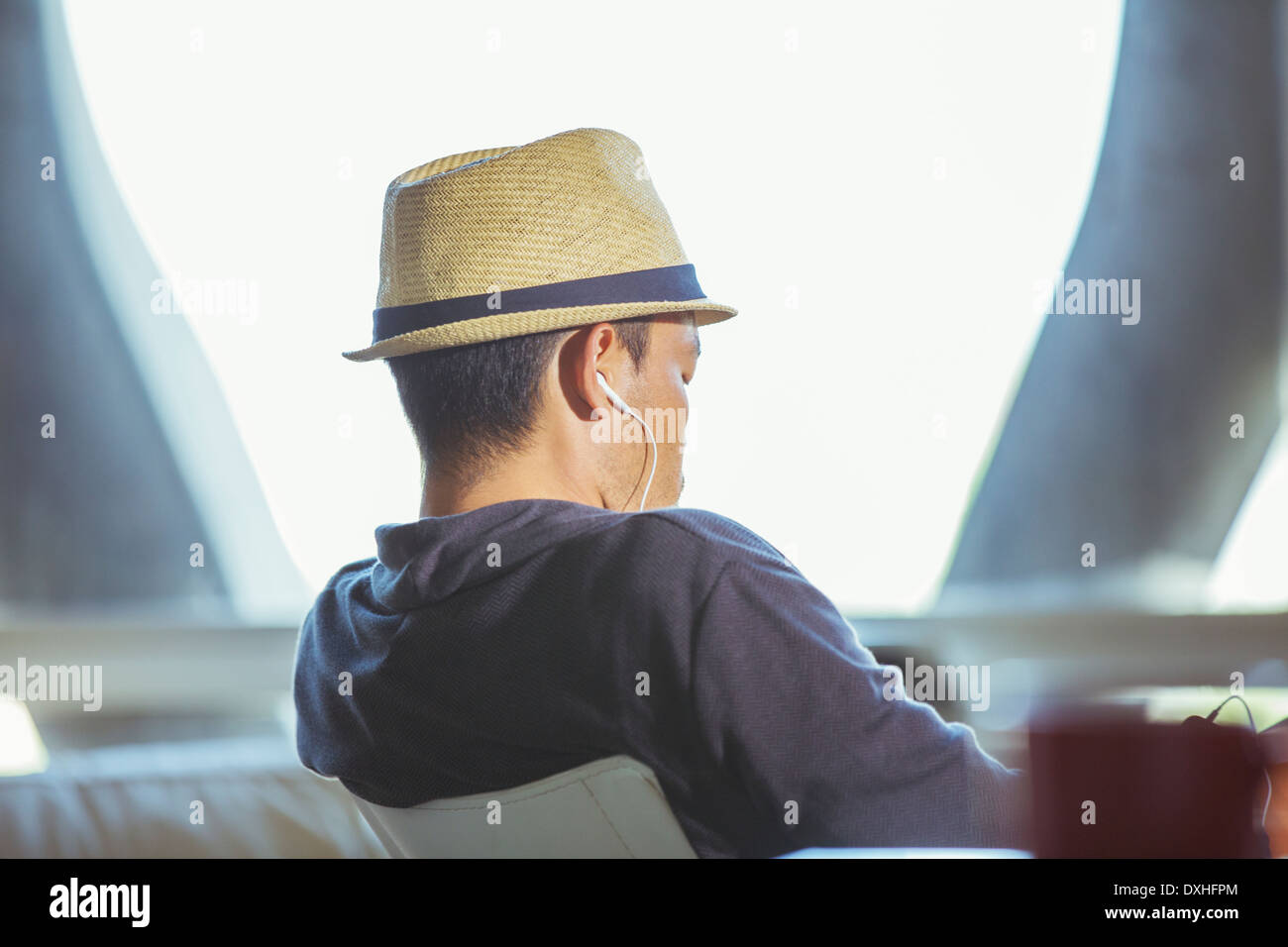 Uomo in fedora che indossano le cuffie Foto Stock