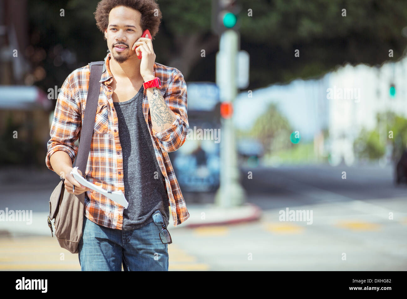 L'uomo parlando al cellulare in crosswalk urbana Foto Stock