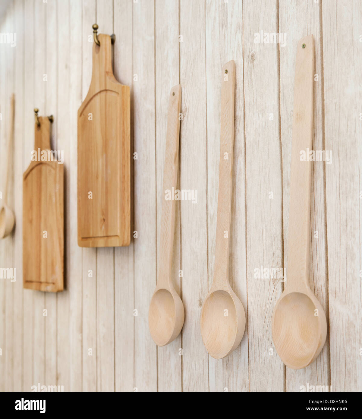 I taglieri e cucchiai di legno appeso alla parete, utensili da cucina, focus su cucchiai Foto Stock