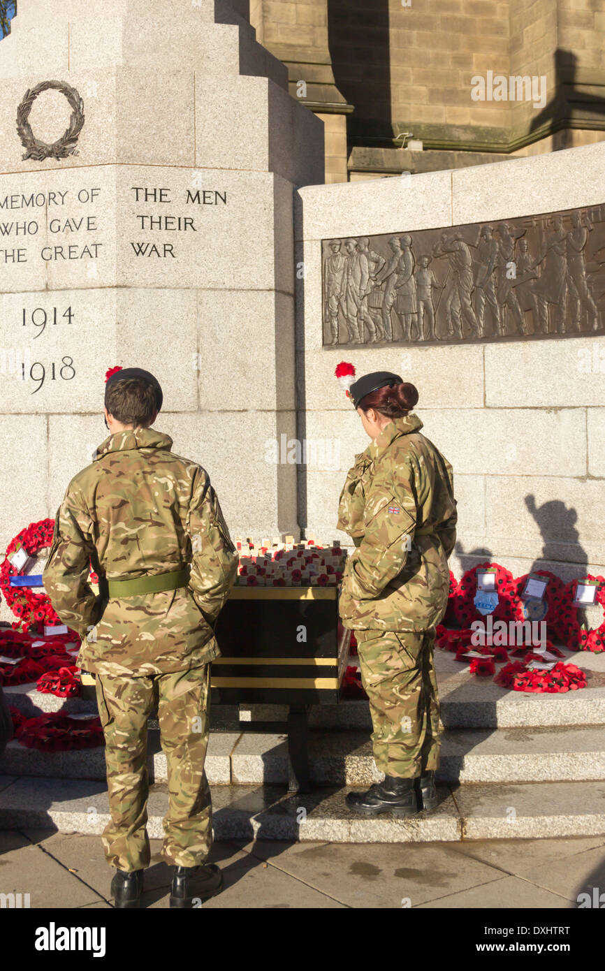 Una giovane donna e un giovane uomo dell'esercito fatiche presso la War Memorial, Bury, Lancashire sul ricordo domenica 2013 Foto Stock