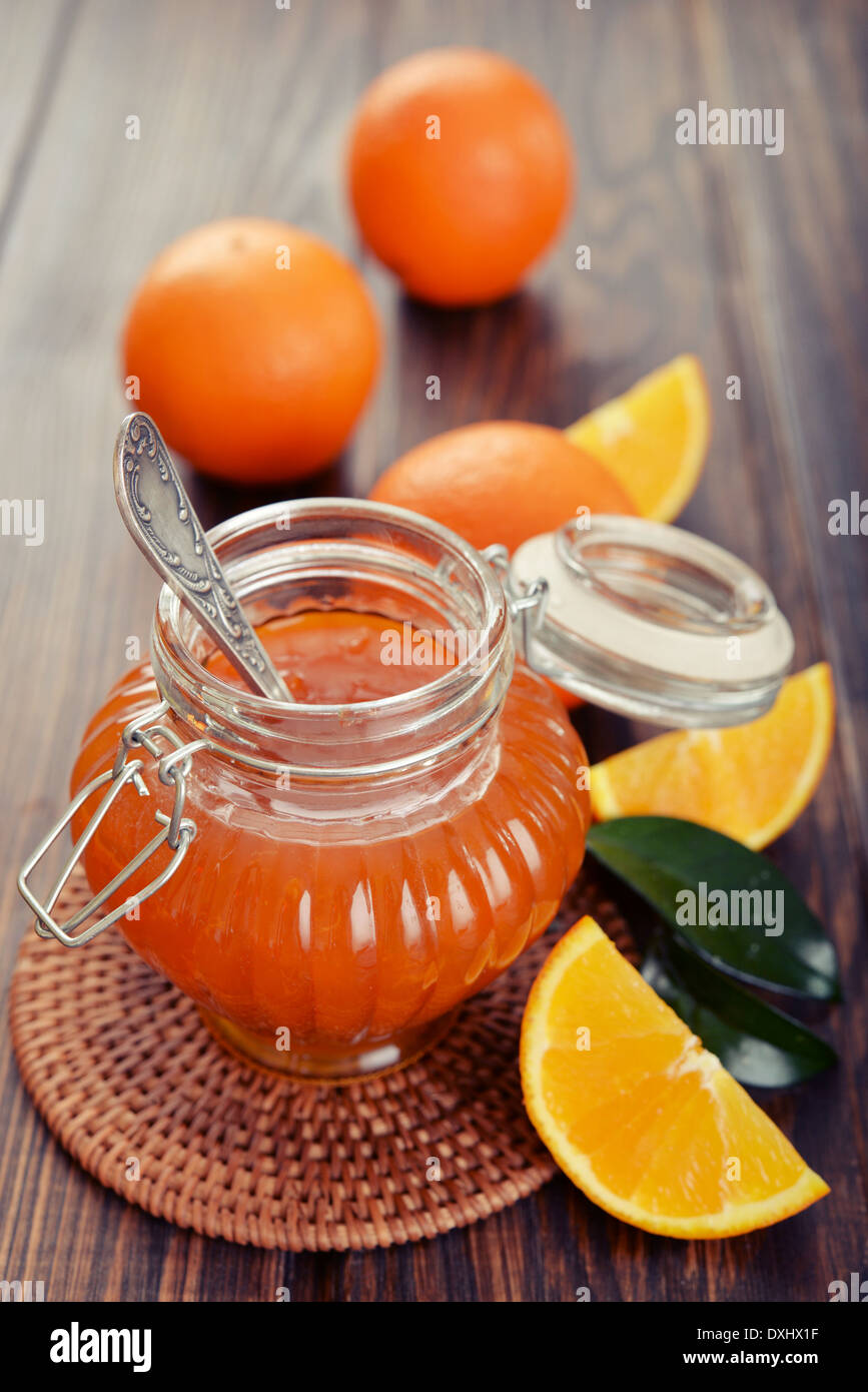Orange inceppamento nel vasetto di vetro su sfondo di legno closeup Foto Stock