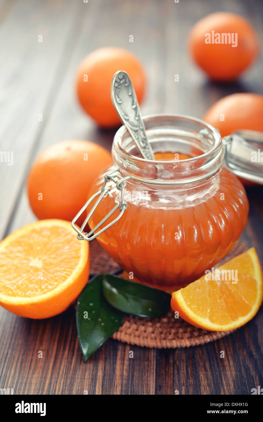 Orange inceppamento nel vasetto di vetro su sfondo di legno closeup Foto Stock