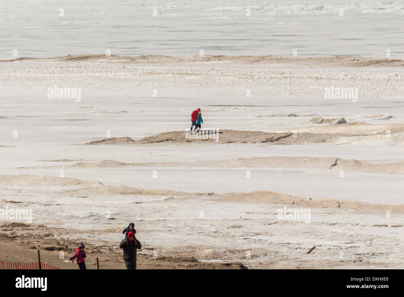 La madre e il bambino sulla sabbia grandi derive di neve su un completamente congelato Lago Huron in Grand Bend, Ontario Foto Stock