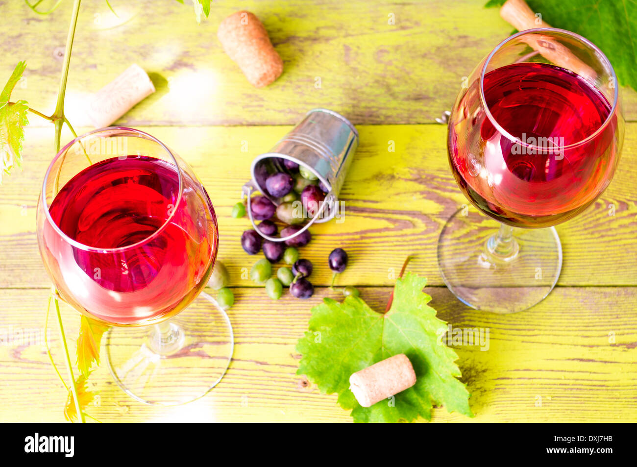 Due bicchieri di vino rosso accanto all'uva in una benna Foto Stock