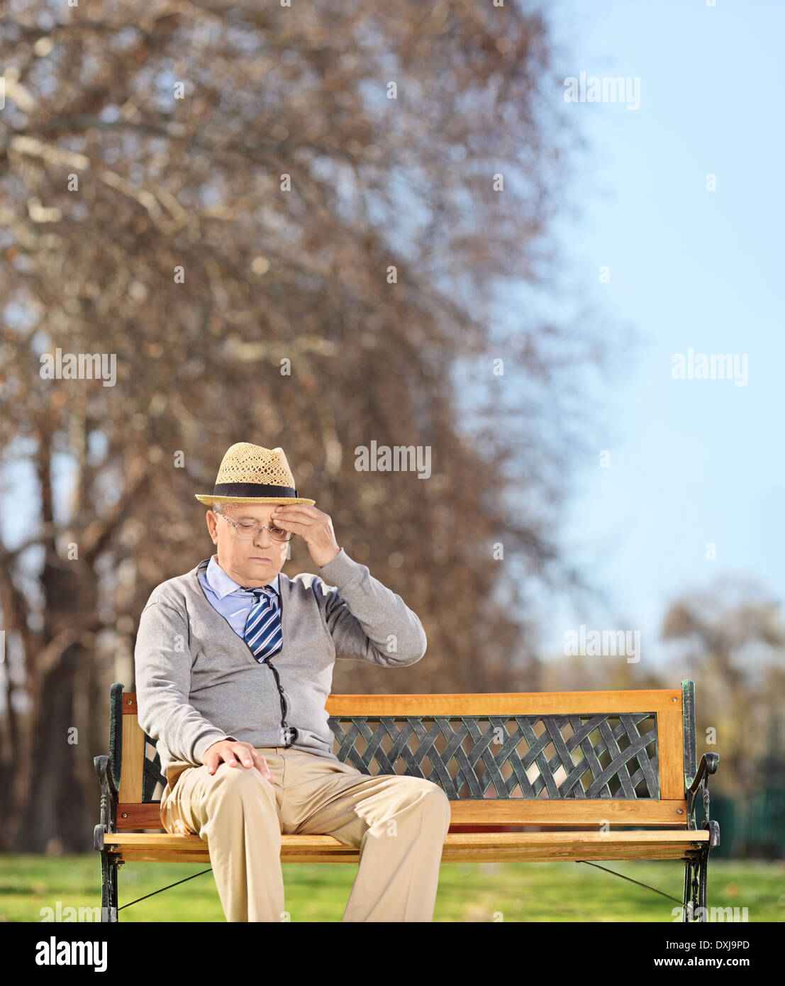 Senior uomo seduto in posizione di parcheggio e con un mal di testa Foto Stock