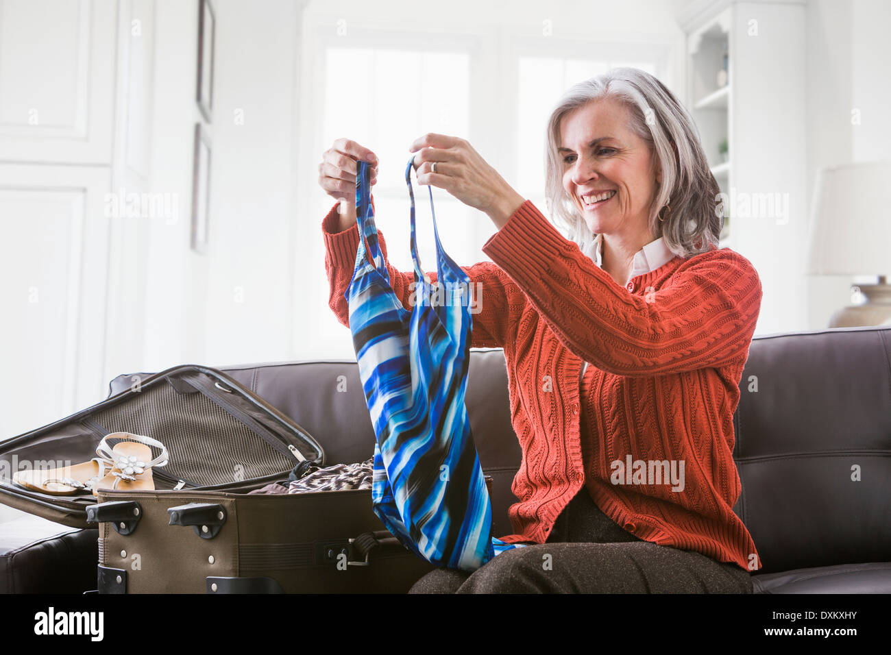 La donna caucasica imballaggio costume da bagno in valigia Foto Stock