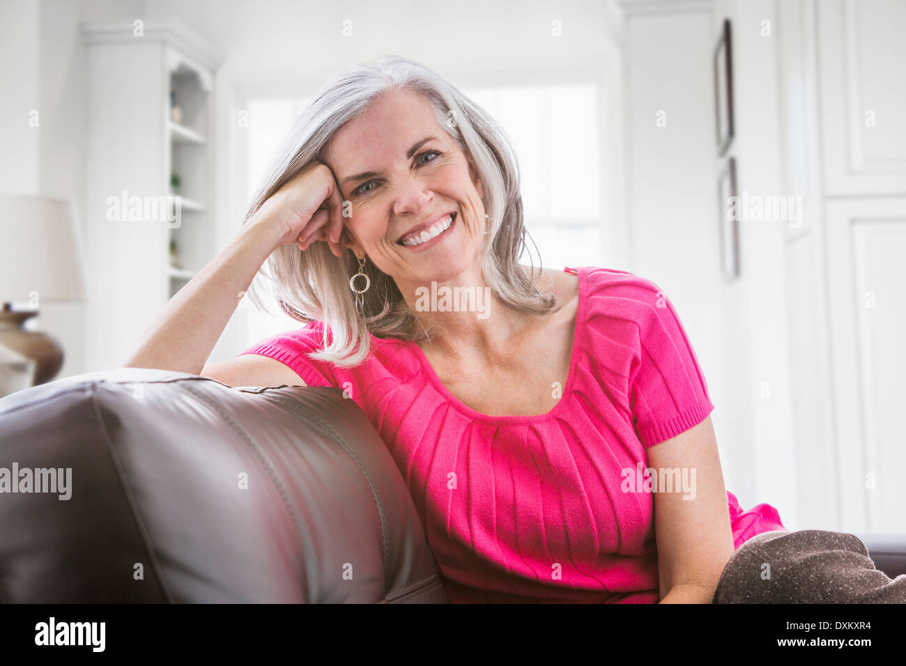 Ritratto di sorridente donna caucasica sul divano Foto Stock