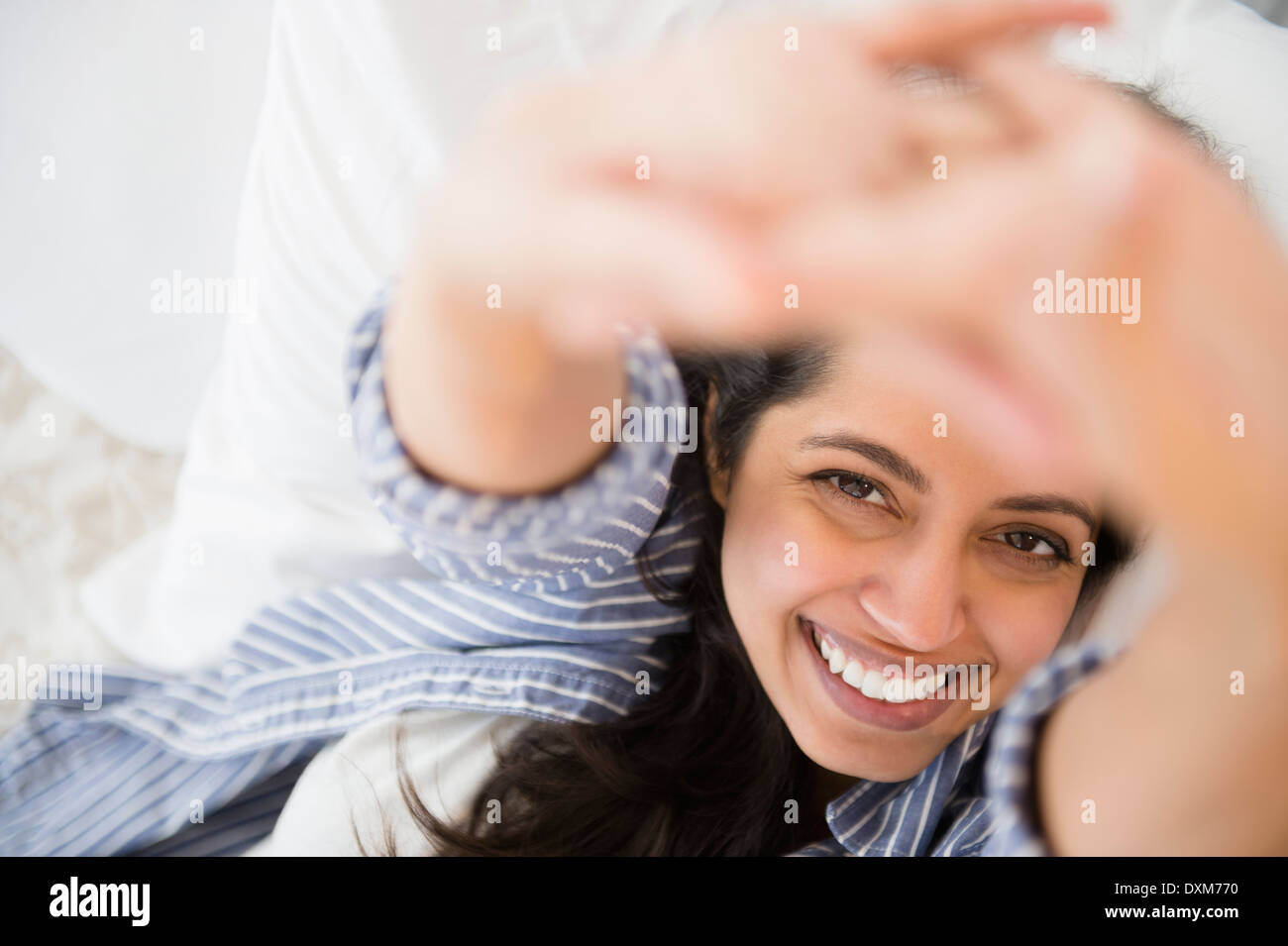 Close up ritratto di sorridere donna asiatica che stabilisce nel letto Foto Stock
