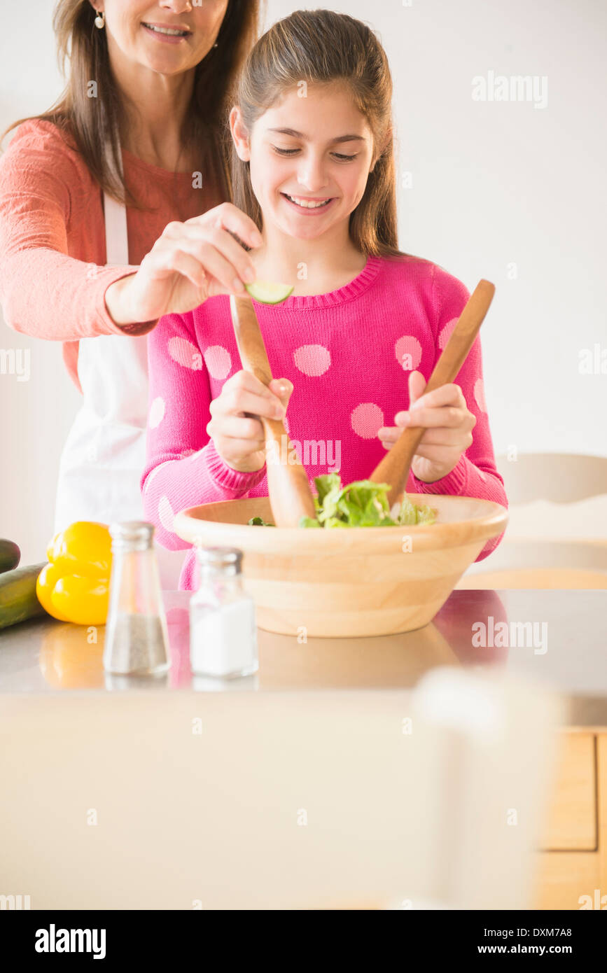 Caucasian madre e figlia tossing insalata in cucina Foto Stock