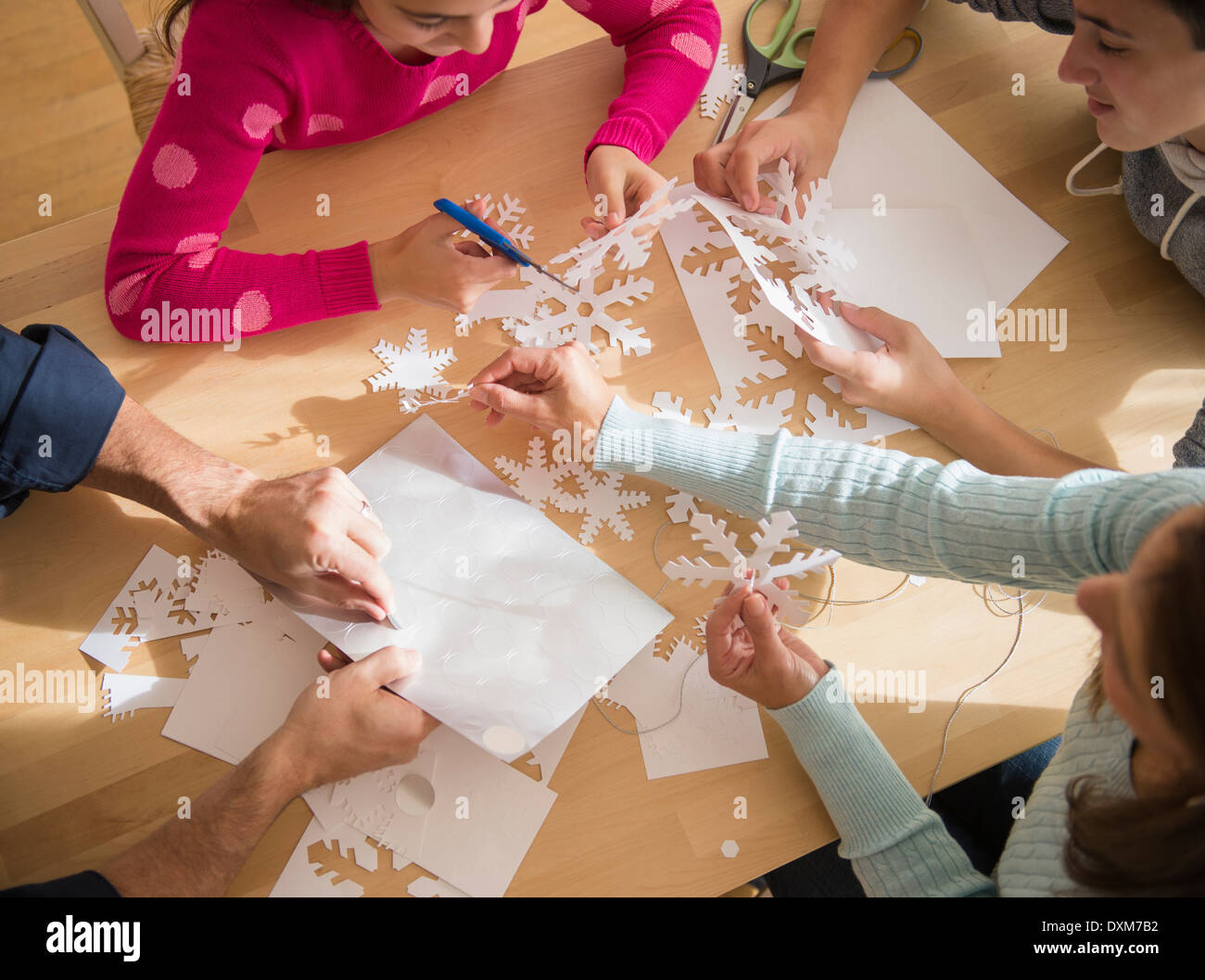 Famiglia caucasica taglio carta fuori i fiocchi di neve Foto Stock