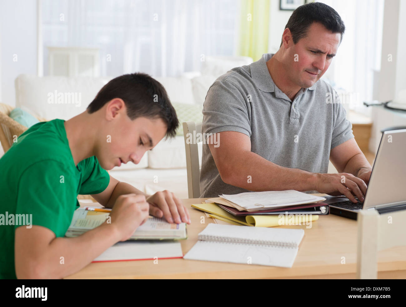 Padre caucasica utilizzando laptop vicino a studiare figlio Foto Stock