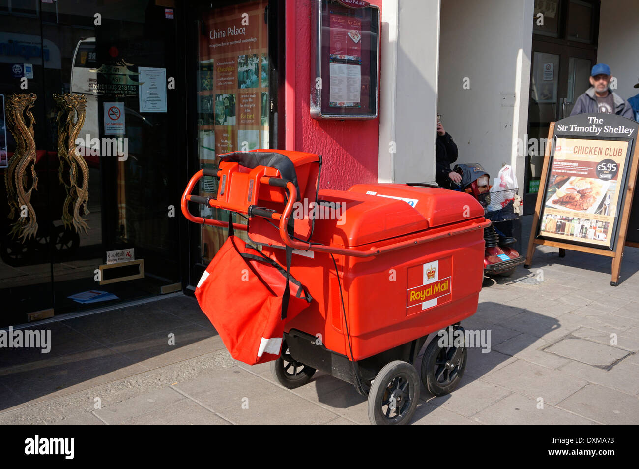 Un postino di alta capacità carrello contenente lettere e pacchi per consegna ora sostituisce la vecchia bicicletta Foto Stock