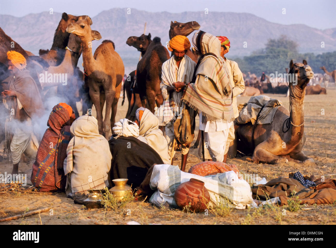 Indian uomini seduti a un fuoco di campo a Pushkar camel fair, India Foto Stock