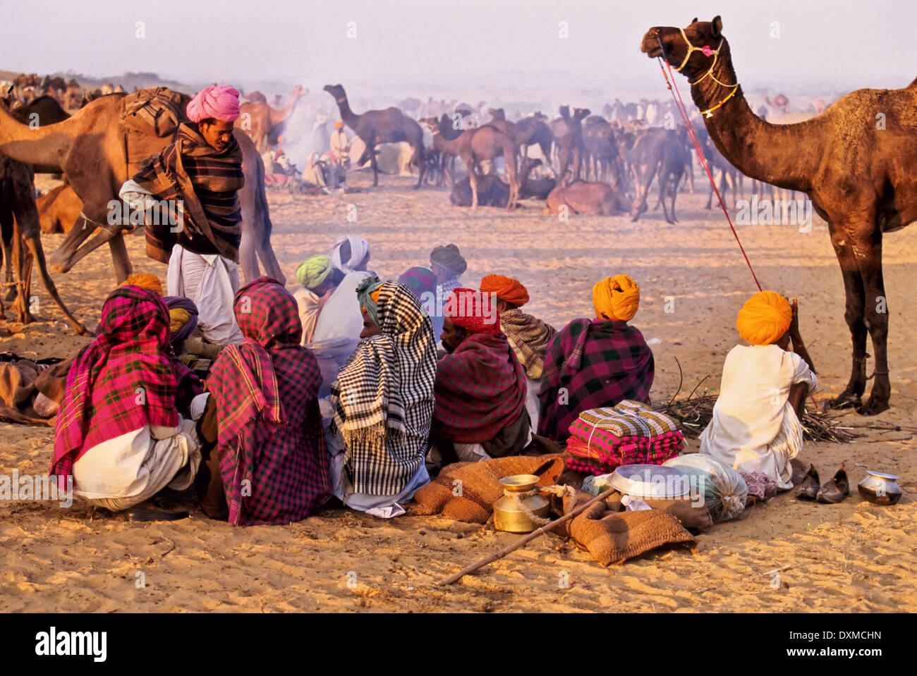 Indian uomini seduti a un fuoco di campo a Pushkar camel fair, India Foto Stock