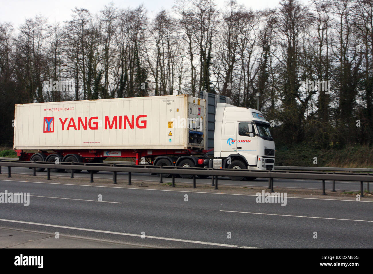 Una Logistica Searon carrello tirando un Yang Ming contenitore lungo una strada12 in Essex, Inghilterra Foto Stock