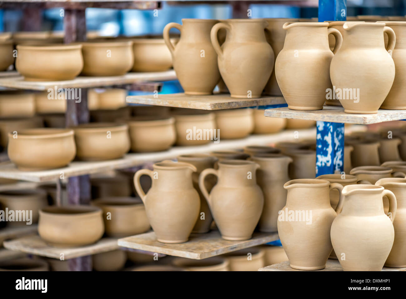 Ripiani con stoviglie in ceramica nel laboratorio di ceramica Foto Stock