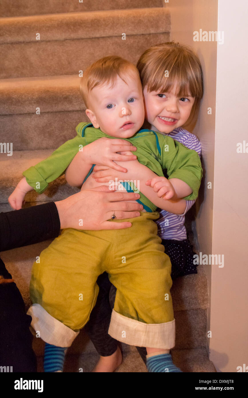 Mamma del canto aiuta il bambino tiene il toddler sulle scale. Foto Stock