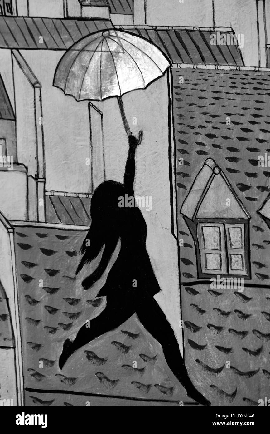 Arte pubblica lavorano nelle strade di Parigi Francia ragazza ballare sui tetti con un ombrello in bianco e nero Foto Stock
