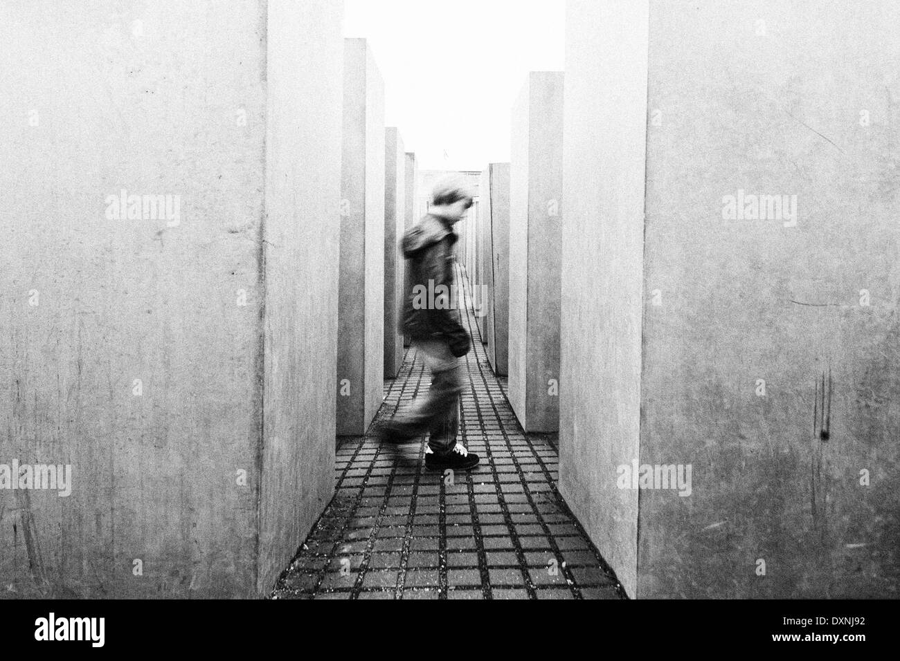 Germania Berlino, vista al Memoriale dell Olocausto con ragazzo andando attraverso Foto Stock