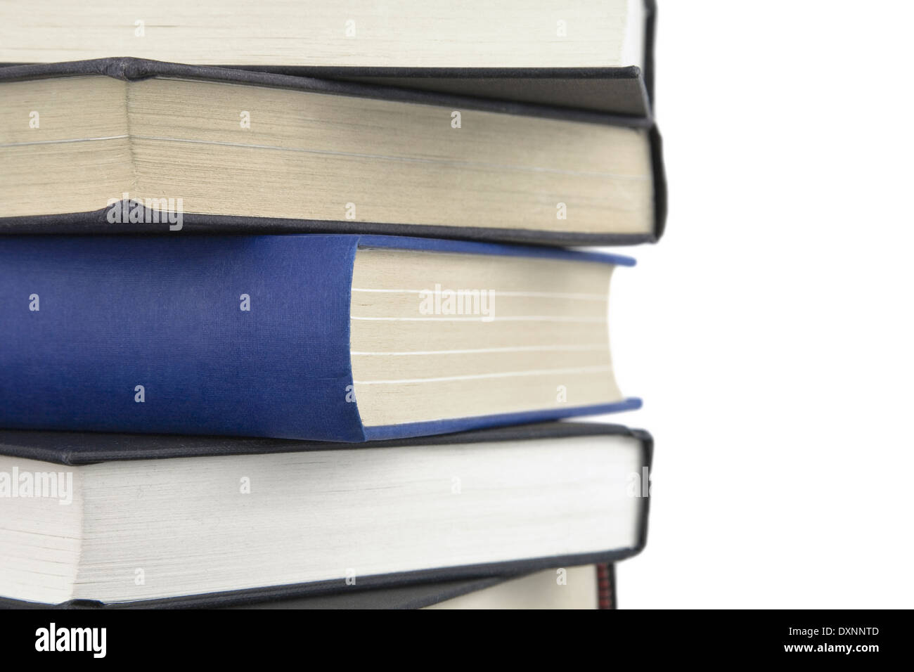 Gruppo di libri impilati alta e un libro in piedi fuori da altri con spina dorsale che mostra. Foto Stock