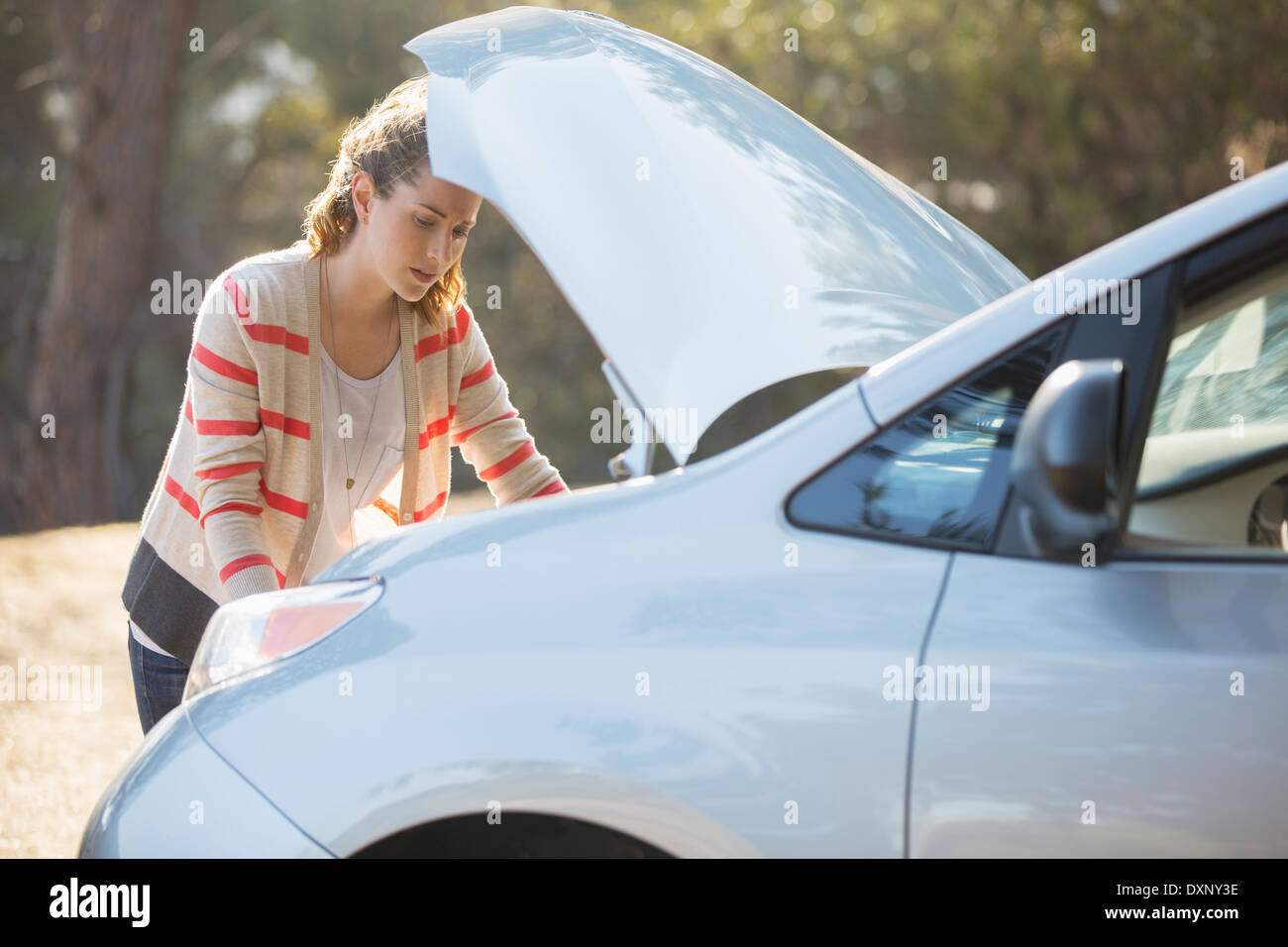 Donna di controllo motore auto in strada Foto Stock