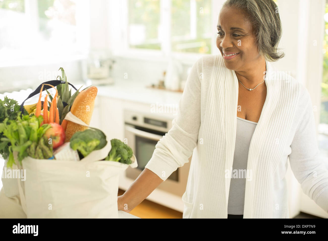 Sorridere le donne anziane con negozi di generi alimentari in cucina Foto Stock