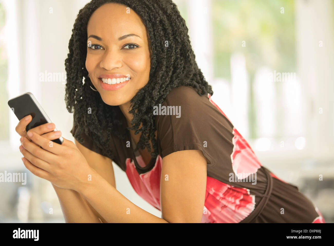Close up ritratto di donna sorridente azienda telefono cellulare Foto Stock