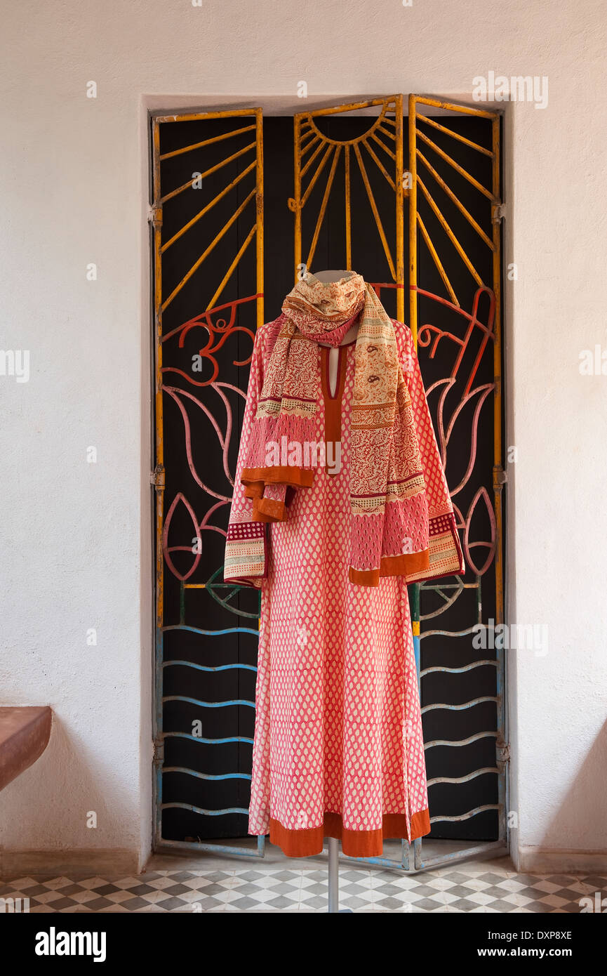 Petterned robe pende sulla concertina ironworked porta nello stato indiano di Goa Foto Stock