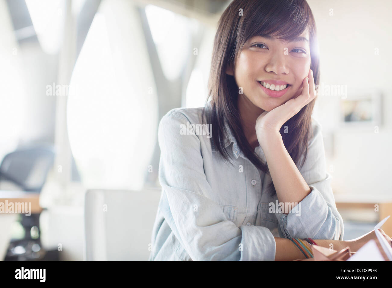 Ritratto di sorridere imprenditrice con testa in mani Foto Stock