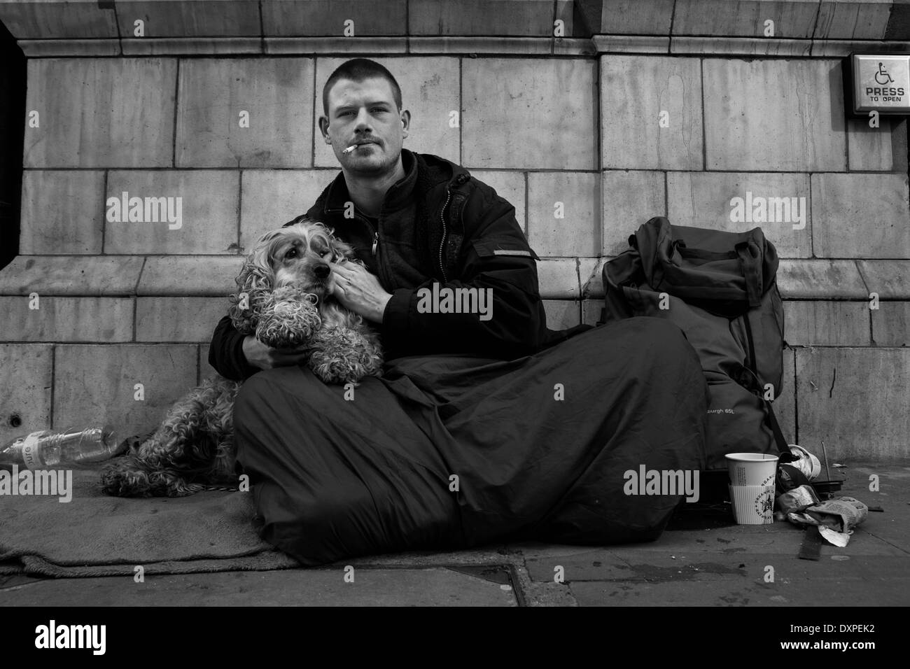 Senzatetto e il suo cane seduto sulle strade di Londra. Foto Stock