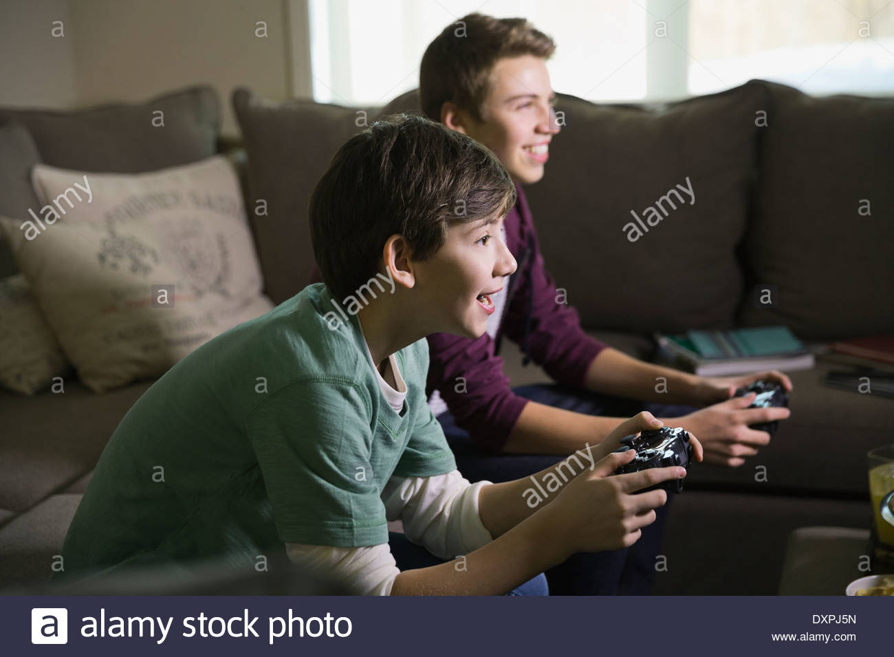 Fratelli di giocare con i videogiochi in salotto Foto Stock