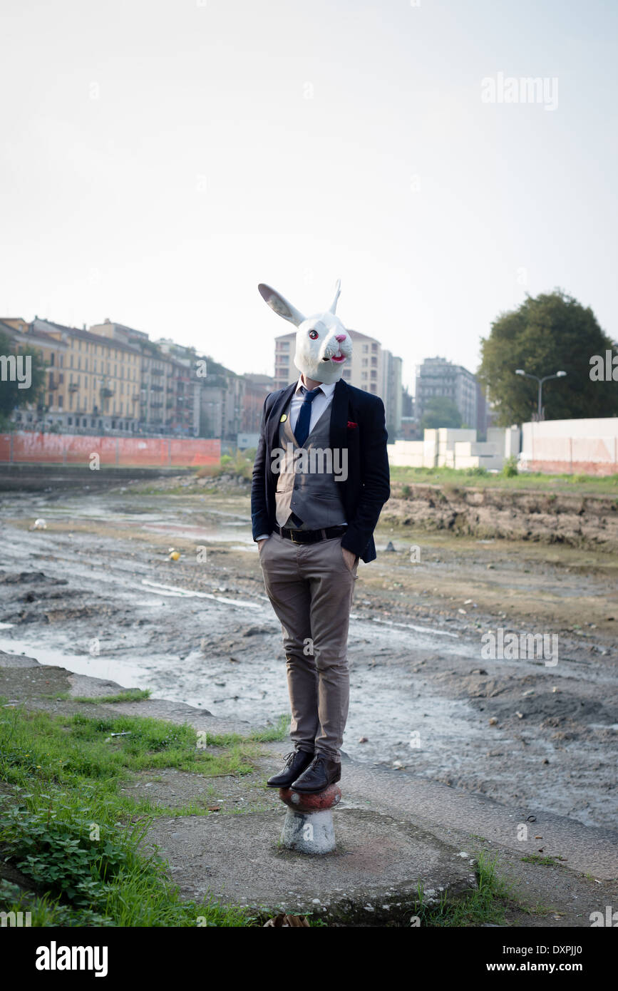 Maschera di coniglio uomo in un paesaggio desolato river Foto Stock
