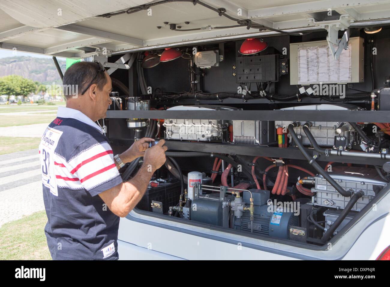 Rio de Janeiro. 28 Mar, 2014. Un uomo prende le foto della parte meccanica del mostravano un bus elettrico prodotto da cinese BYD a Rio de Janeiro, 28 marzo 2014. Un mese di esposizione per BYD del bus elettrico è stato inaugurato qui il venerdì. © Xu Zijian/Xinhua/Alamy Live News Foto Stock