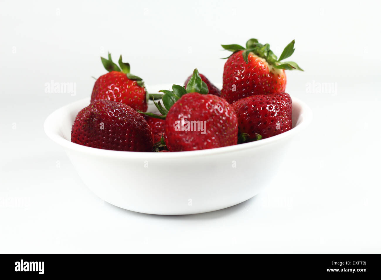 Fragole fresche in un vaso bianco su sfondo bianco Foto Stock