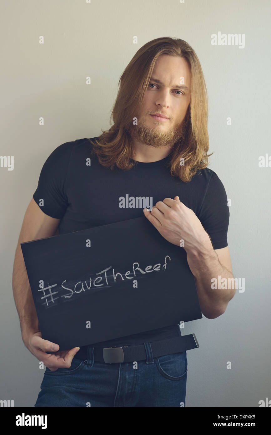 Un uomo con la barba tenendo un cartello per promuovere 'salva il reef' Foto Stock